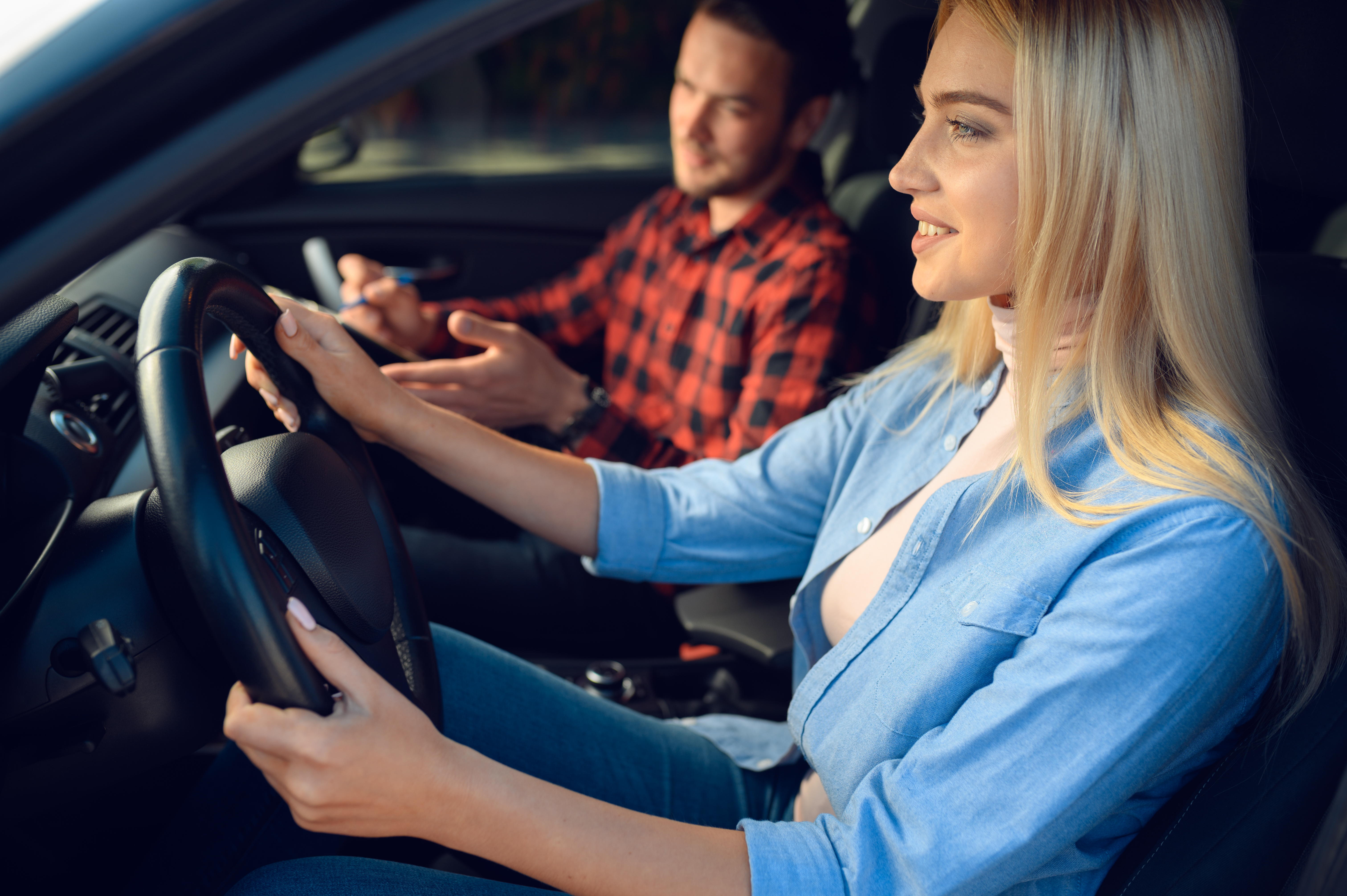 Student and male instructor in car, driving school