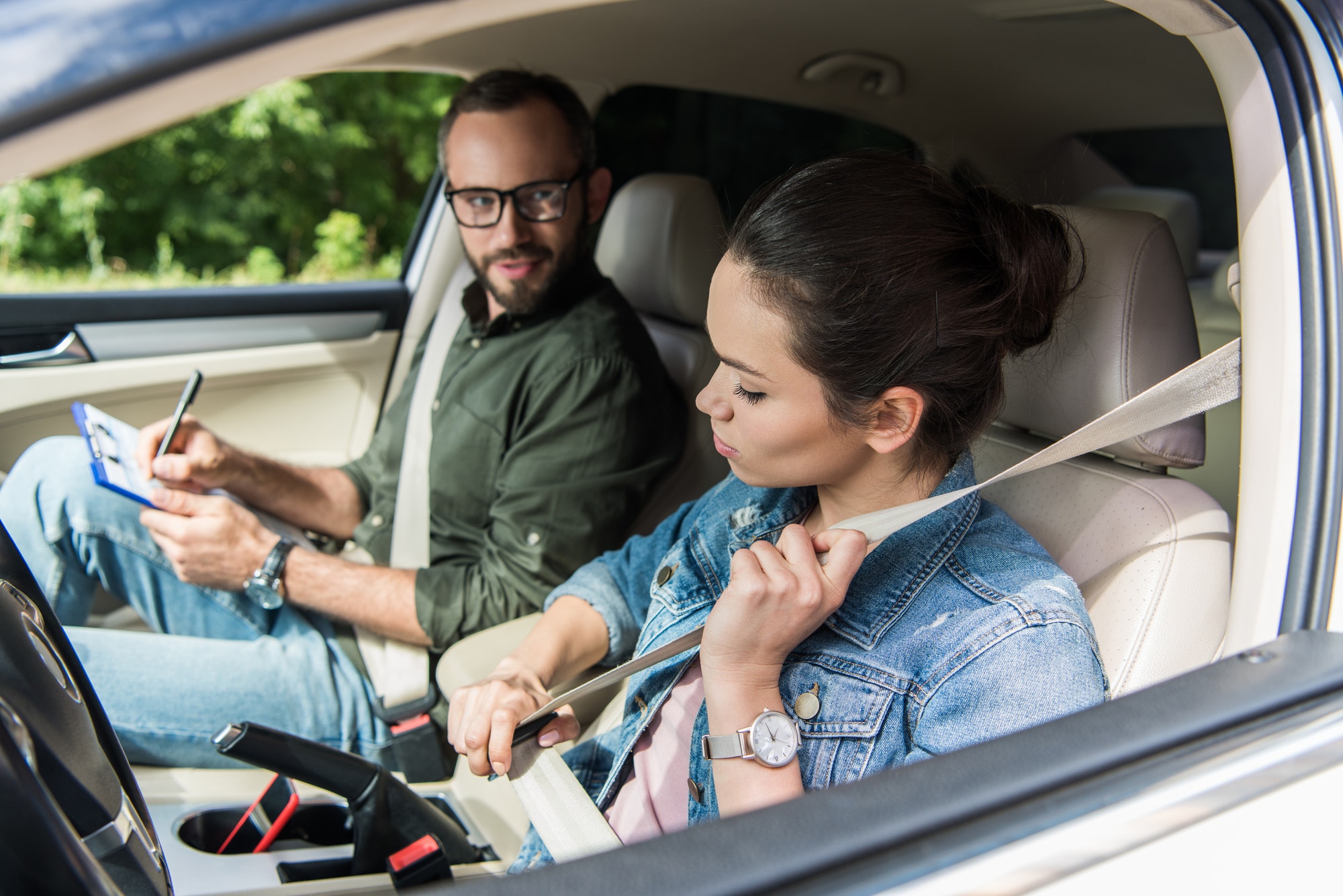 student-fastening-seat-belt-in-car-during-driving-test.jpg