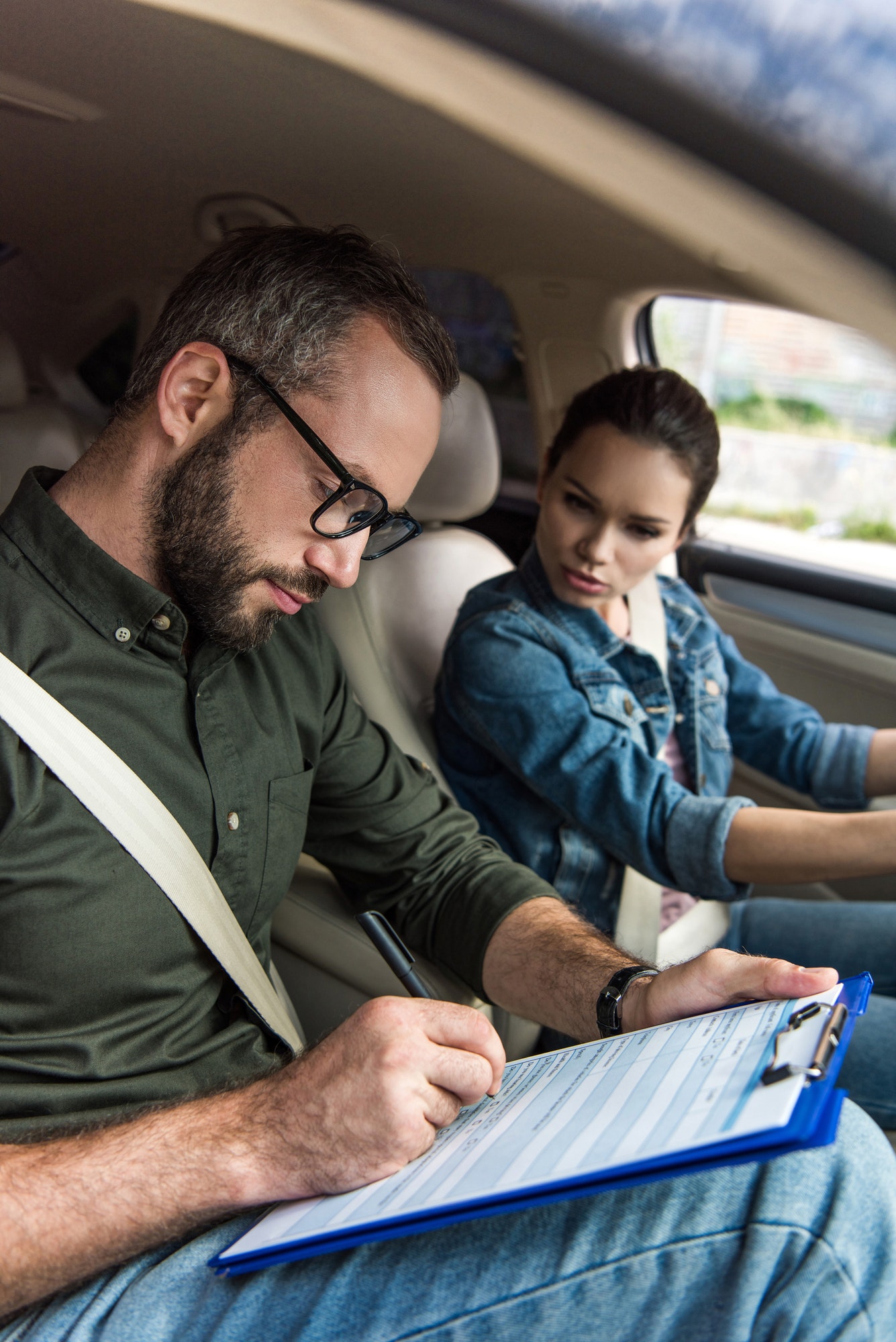 teacher-writing-something-to-clipboard-during-driving-test.jpg